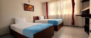 a hotel room with two beds and a window at Hotel el Duque Internacional, Bogotá in Bogotá +22 photos