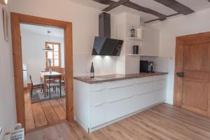 a kitchen with white cabinets and a dining room at Krebiehls Winkelhof in Herxheim am Berg +37 photos