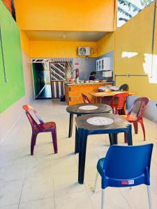 a room with tables and chairs and a kitchen at Pousada e Hostel das Rosas in Barreirinhas