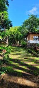 a field of grass with a building and trees at Casa Bambú Hotel in Masaya