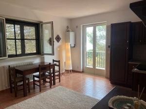 a living room with a table and chairs and windows at Agriturismo Monte Sacro in Mattinata