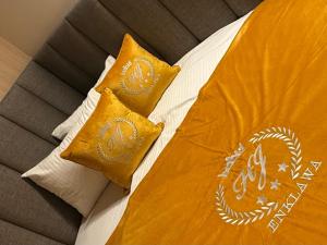 a bed with two yellow pillows on top of it at ENKLAWA IMPERIUM- DOM WAKACYJNY-APARTAMENTY NAD JEZIOREM- 20 km od TORUNIA-PLAŻA,JACUZZI 