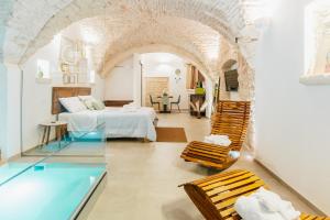 a hotel room with a bed and a swimming pool at Gattoni Suite by Rentbeat in Martina Franca +29 photos