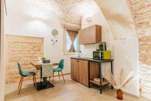 a kitchen with a table and chairs and a dining room at Gattoni Suite by Rentbeat in Martina Franca
