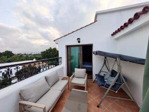 a balcony with a couch and chairs on a white building at Andalucia Family-Only Aparthotel in Cabo Negro