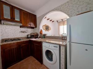 a kitchen with a washer and a white refrigerator at Andalucia Family-Only Aparthotel in Cabo Negro