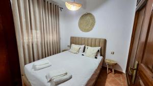 a bedroom with a bed with white sheets and pillows at Andalucia Family-Only Aparthotel in Cabo Negro +13 photos