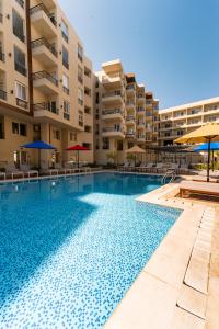 a swimming pool in front of a apartment building at Aqua Fun Resort in Hurghada
