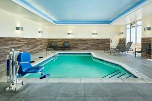 a pool in a hotel room with a blue chair at Fairfield Inn & Suites by Marriott Sidney in Sidney