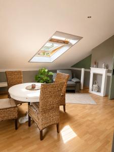 a living room with a table and chairs and a skylight at Green Door Loft Stilvolles 160 m2 Apartment Balkon Gartenblick Workstation Hundefreundlich in Ibbenbüren