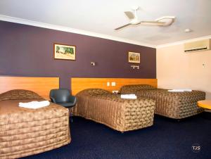 a hotel room with two beds and a ceiling at SunPalms Motel in Rockhampton