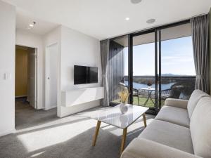 a living room with a couch and a tv at Lakeview on Grazier in Belconnen
