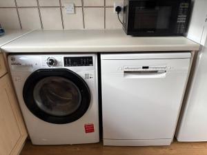 a microwave and a washing machine in a kitchen at Cairngorm Cottage in Aviemore