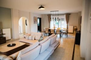 a living room with a couch and a dining room at Exclusive Villa with Pool in Káto Ássos