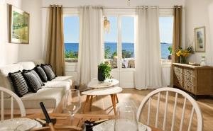 un salon avec un canapé et une table avec des chaises dans l'établissement Beachfront Pleasure, à Kypri