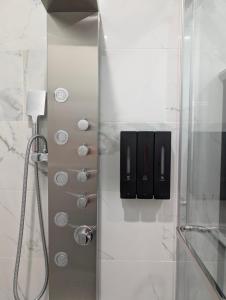 a shower with a glass door in a bathroom at Modern Comfort - Minimal Style in Elmont +52 photos