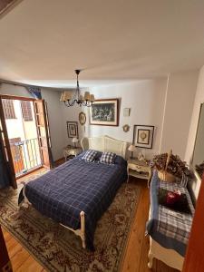 a bedroom with two beds and a chandelier at Casona de la Tauna in Sos del Rey Católico