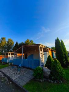 a blue and white house with a porch at OliMarii domki nad jeziorem Jezioro Złotnickie Karłowice 19 a,b in Karłowice