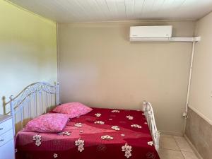 a small bedroom with a bed with a red blanket at L'île au Vert in Gros-Morne +28 photos