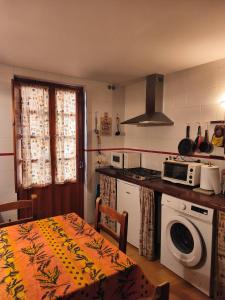 a kitchen with a table and a stove and a microwave at Casona de la Tauna in Sos del Rey Católico