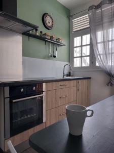 a kitchen with a coffee cup on a table at Perle proche gare maritime et croisières in Pointe-à-Pitre
