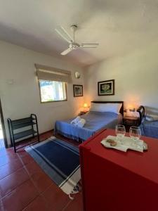 a bedroom with two beds and a table with a red table sidx sidx at Bocaina Sítio da Vovó in Engenheiro Paulo de Frontin