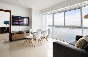 a living room with a table and chairs and a television at THE VIEW AT RIVEFRONT by Bahama Rentals in Guayaquil