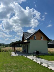 a house with a pavilion next to a field at Noclegi u Dąbka 2 in Głębokie