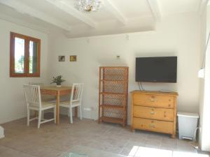 een woonkamer met een televisie en een tafel met stoelen bij Vienna Cottage in Wenen