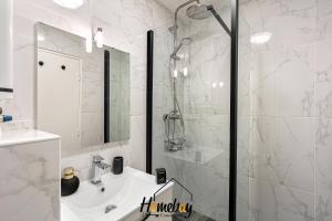 a white bathroom with a shower and a sink at Les Jardins, Golfe-Juan in Vallauris