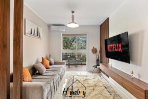 a living room with a couch and a flat screen tv at Les Jardins, Golfe-Juan in Vallauris