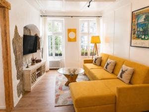 a living room with a yellow couch and a table at 120m2 l Golden Castle Loft l Old Town l Thun in Thun