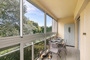 a dining room with a table and chairs and large windows at Les Jardins, Golfe-Juan in Vallauris