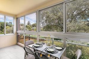 a dining room with large windows and a table and chairs at Les Jardins, Golfe-Juan in Vallauris