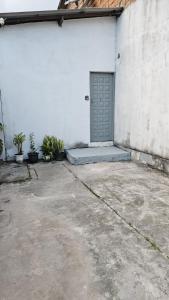 a white building with a door and some plants at Casa Vigia 1 Quarto in Vigia