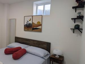 a bedroom with a bed with red pillows on it at Modern Comfort - Minimal Style in Elmont