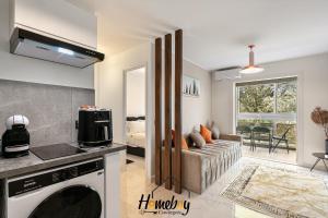 a kitchen and a living room with a couch at Les Jardins, Golfe-Juan in Vallauris +2 photos