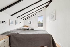 a white bedroom with a bed and a window at 1395-Thisted-Revlingvej-5 in Nørre Vorupør