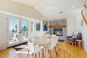 a dining room with a table and a fireplace at Pinetree Palace in Lake Arrowhead