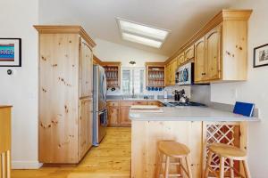 a kitchen with wooden cabinets and a kitchen island with stools at Pinetree Palace in Lake Arrowhead +21 photos