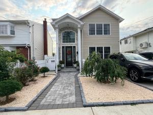a house with a car parked in front of it at Modern Comfort - Minimal Style in Elmont