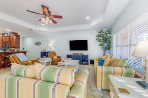 a living room with couches and a flat screen tv at Sunset Over Paradise in South Padre Island