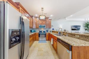 a kitchen with wooden cabinets and a refrigerator at Sunset Over Paradise in South Padre Island