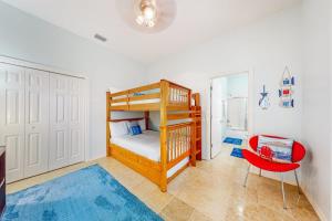 a bedroom with a bunk bed and a red chair at Sunset Over Paradise in South Padre Island +20 photos