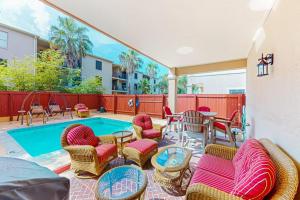 a patio with a pool and chairs and a table at Sunset Over Paradise in South Padre Island