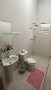 a white bathroom with a toilet and a sink at Pousada flores de ipê in Capitólio +35 photos