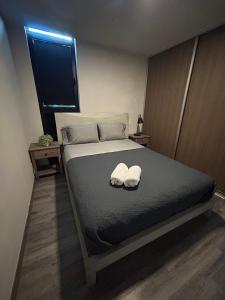 a bedroom with a bed with two towels on it at Nunciatura Centrico in San José