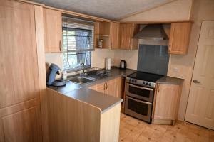 a kitchen with wooden cabinets and a stove top oven at Kota Kiva in Hulshorst