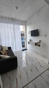 a living room with a couch and a large window at Casa Vigia 2 Quartos in Vigia