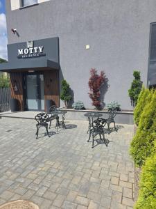 a group of benches sitting in front of a building at Motty Residence in Vicovu de Sus